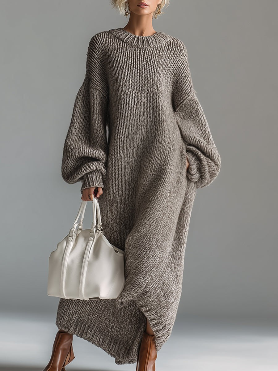 Woman wearing an oversized chunky knit maxi jumper dress with balloon sleeves and ribbed crew neck
