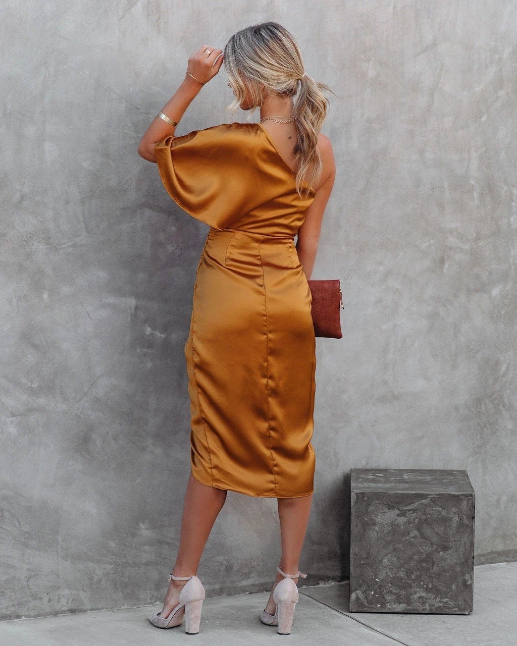Woman wearing a one shoulder satin cocktail dress with ruched waist and wrap-front split midi skirt - view 7