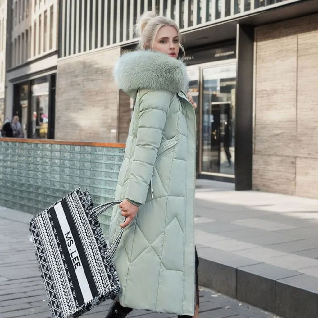 Woman wearing a long cream quilted winter coat with faux fur trimmed hood - view 10