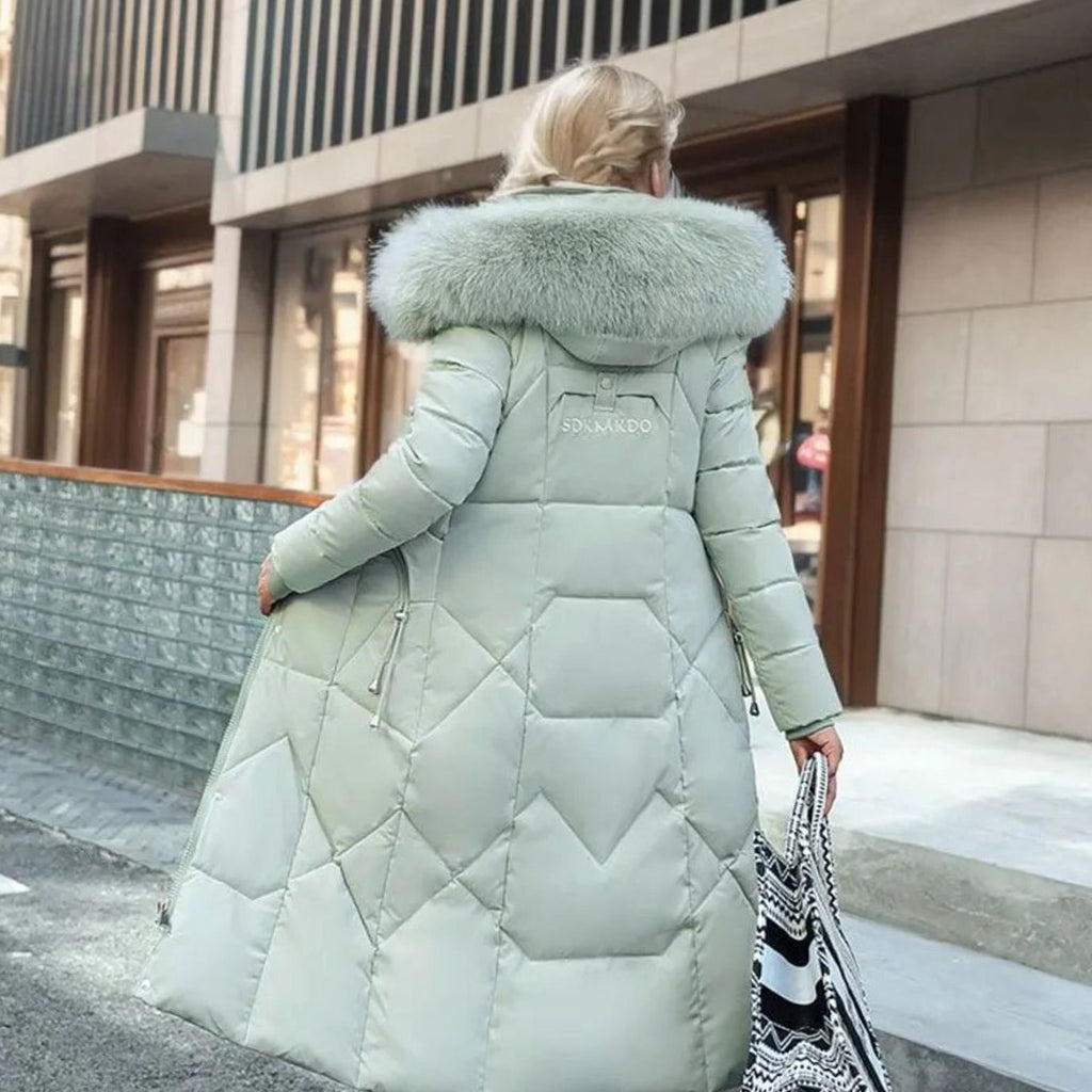 Woman wearing a long cream quilted winter coat with faux fur trimmed hood - view 12