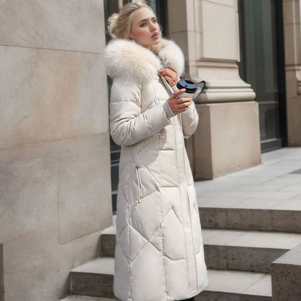 Woman wearing a long cream quilted winter coat with faux fur trimmed hood - view 2