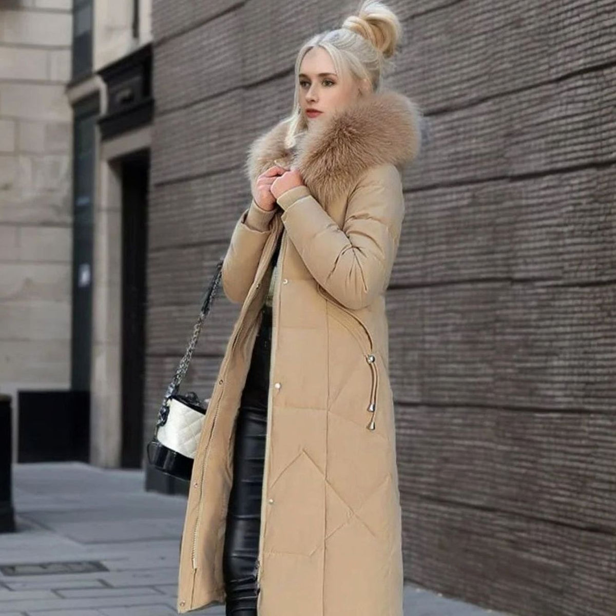 Woman wearing a long cream quilted winter coat with faux fur trimmed hood - view 20
