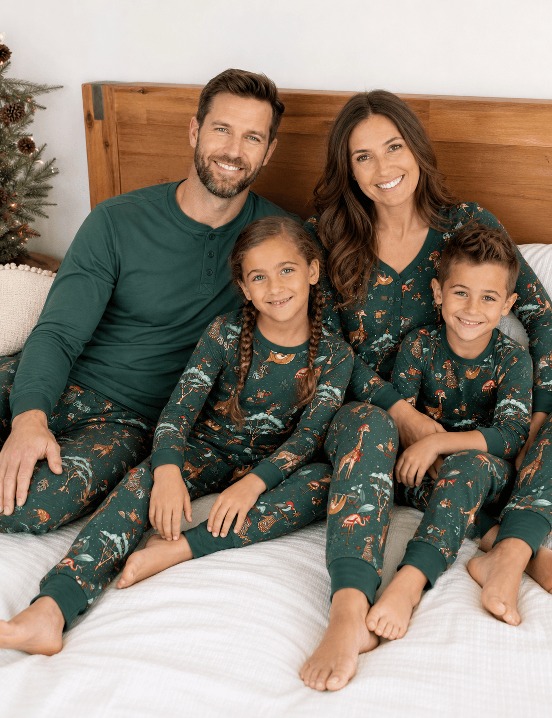 Family wearing matching forest green Christmas pyjamas with safari animal print - view 5