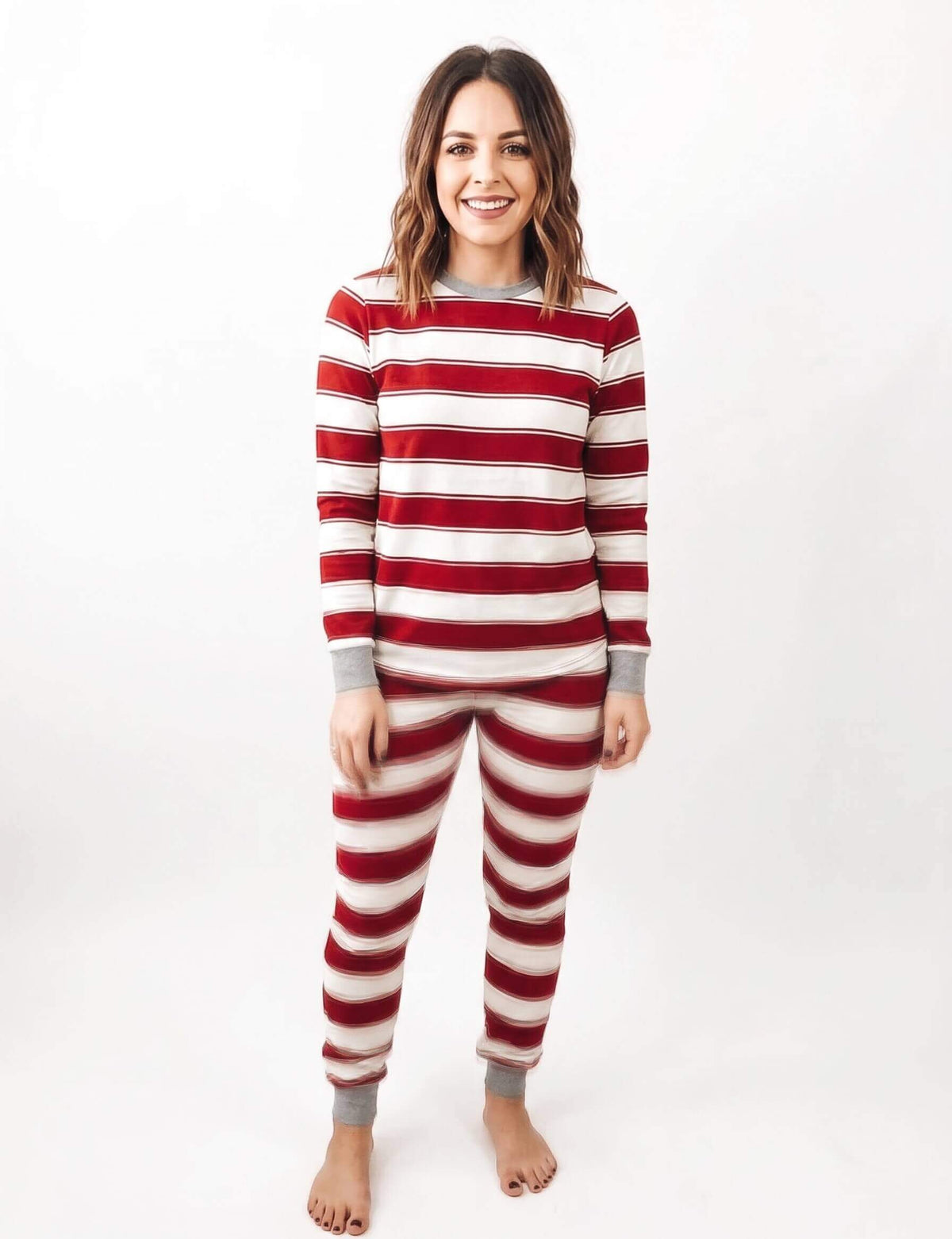 Family wearing matching red and white striped Christmas pyjamas with grey ribbed cuffs - view 10