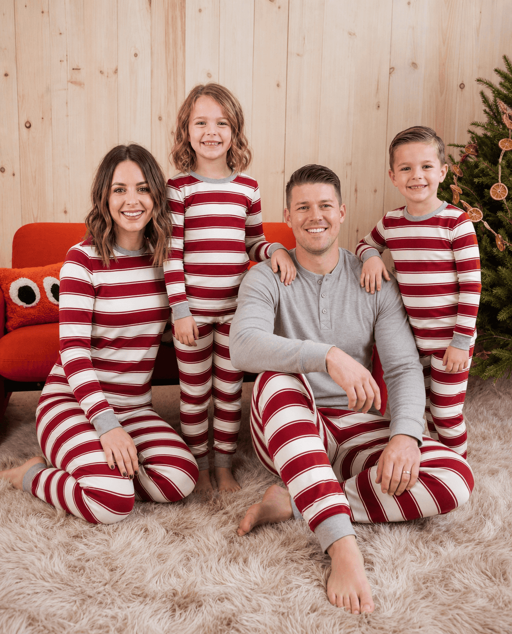 Family wearing matching red and white striped Christmas pyjamas with grey ribbed cuffs - view 6