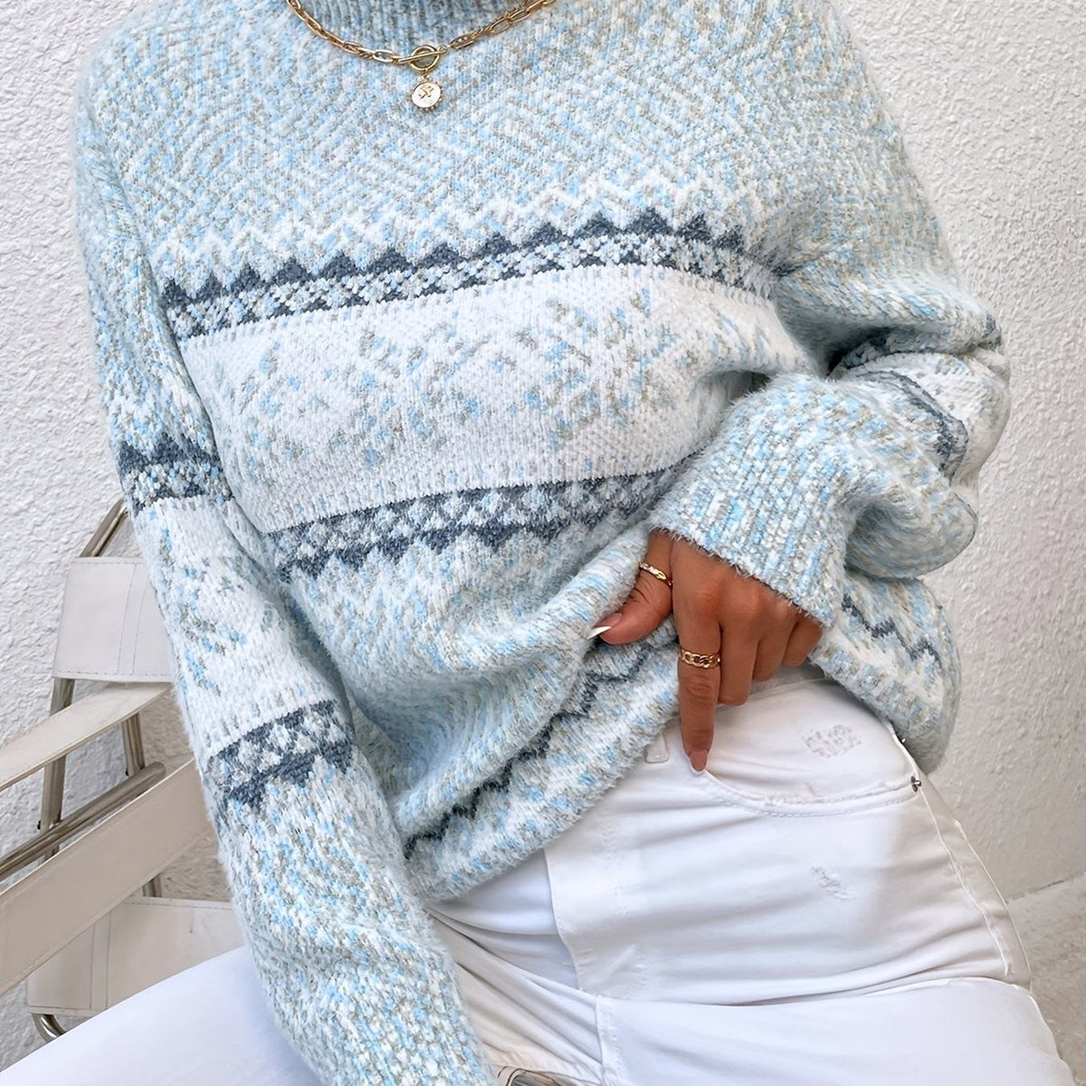 Woman wearing a blue speckled Fair Isle snowflake mock neck jumper with white jeans - view 16
