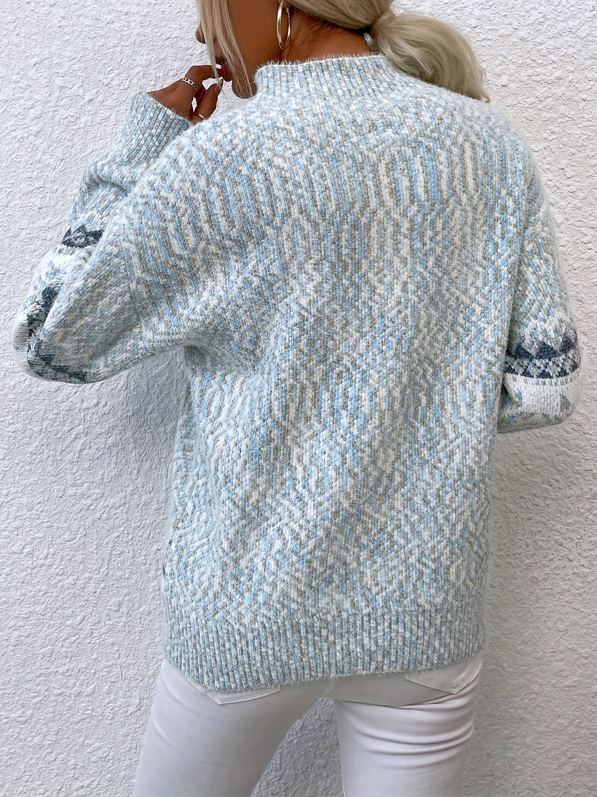 Woman wearing a blue speckled Fair Isle snowflake mock neck jumper with white jeans - view 18