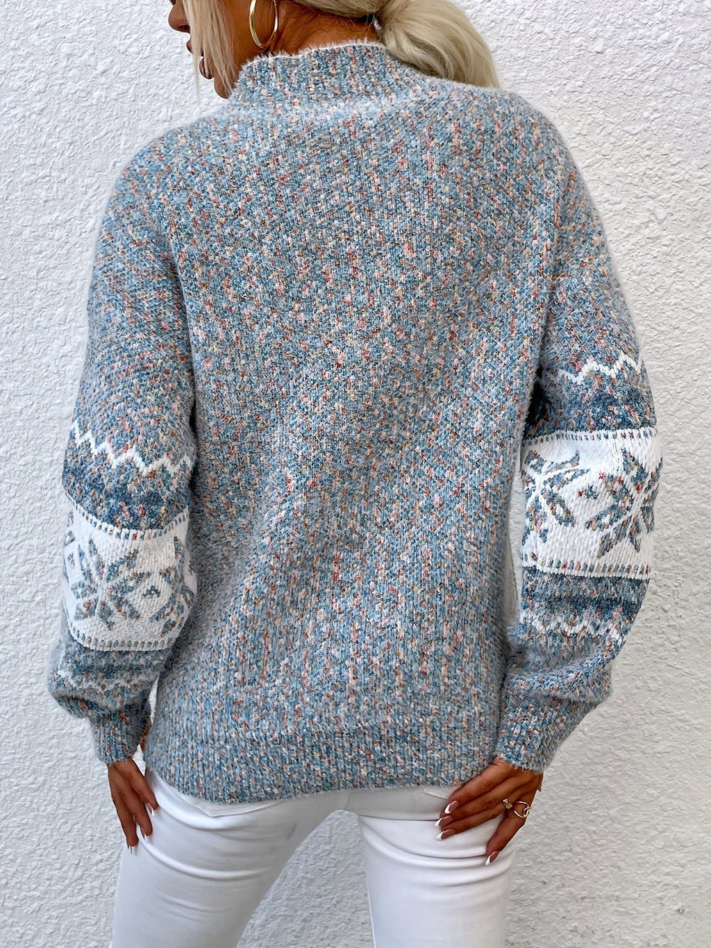 Woman wearing a blue speckled Fair Isle snowflake mock neck jumper with white jeans - view 2