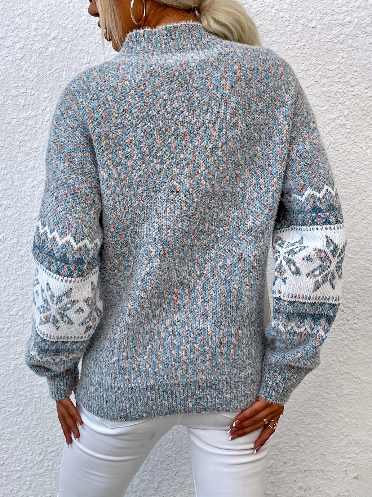 Woman wearing a blue speckled Fair Isle snowflake mock neck jumper with white jeans - view 2