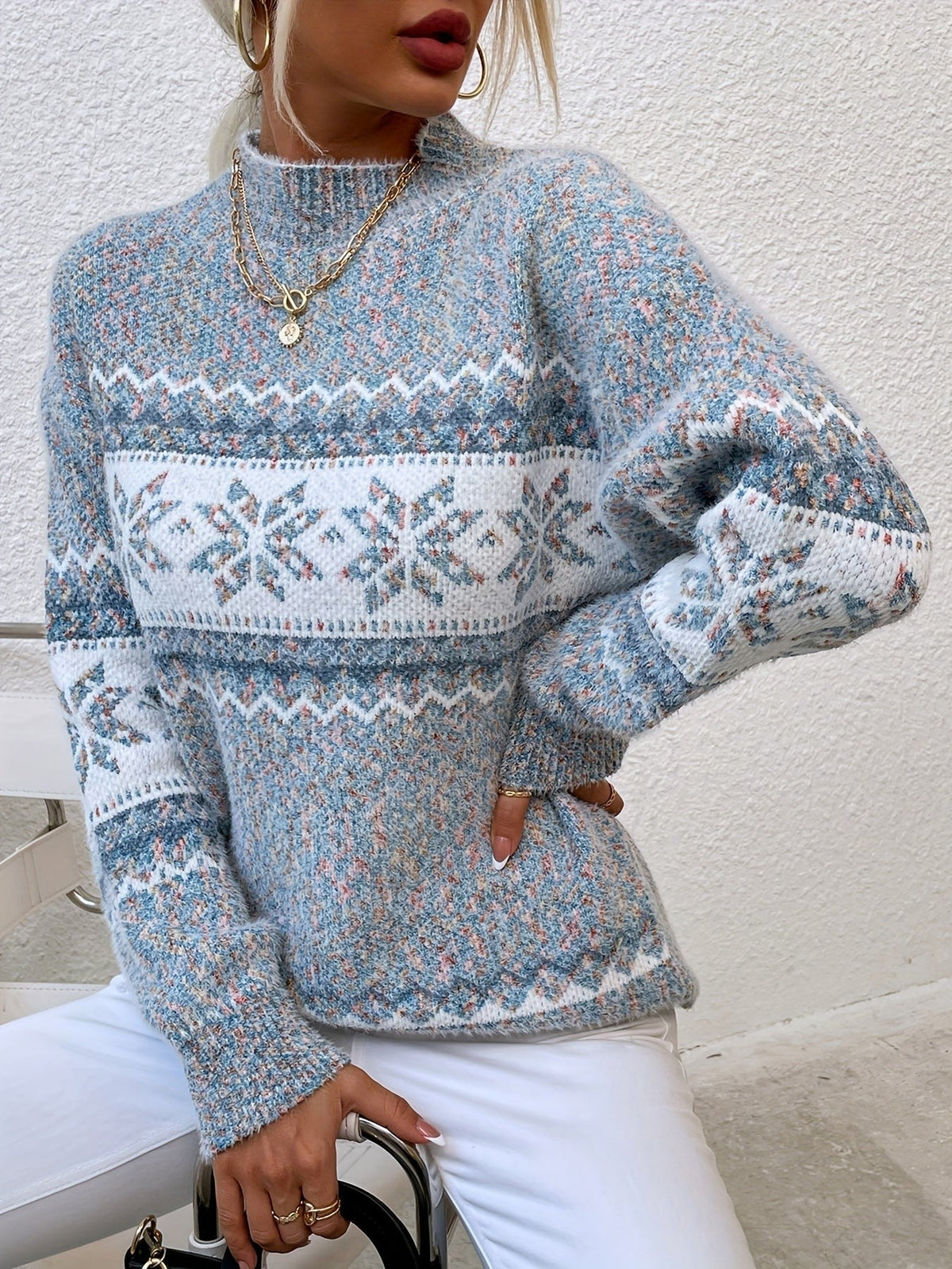 Woman wearing a blue speckled Fair Isle snowflake mock neck jumper with white jeans - view 3