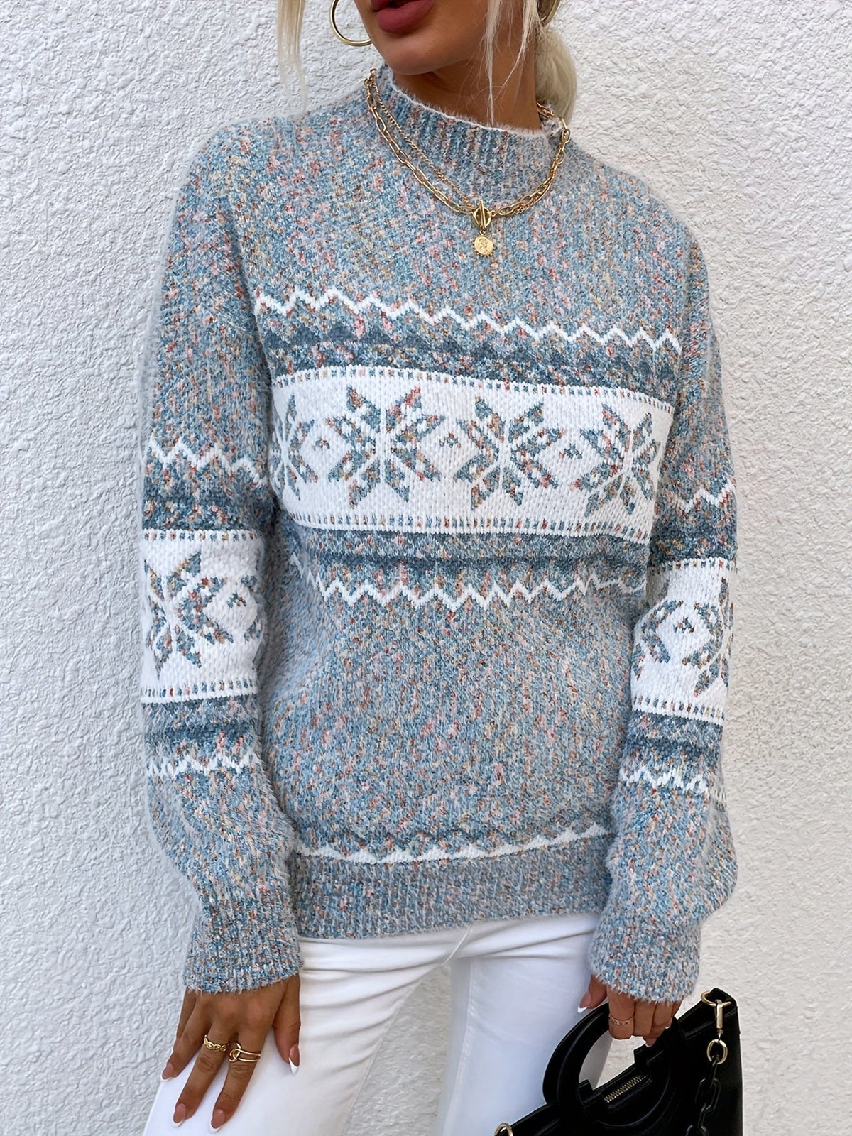 Woman wearing a blue speckled Fair Isle snowflake mock neck jumper with white jeans - view 4