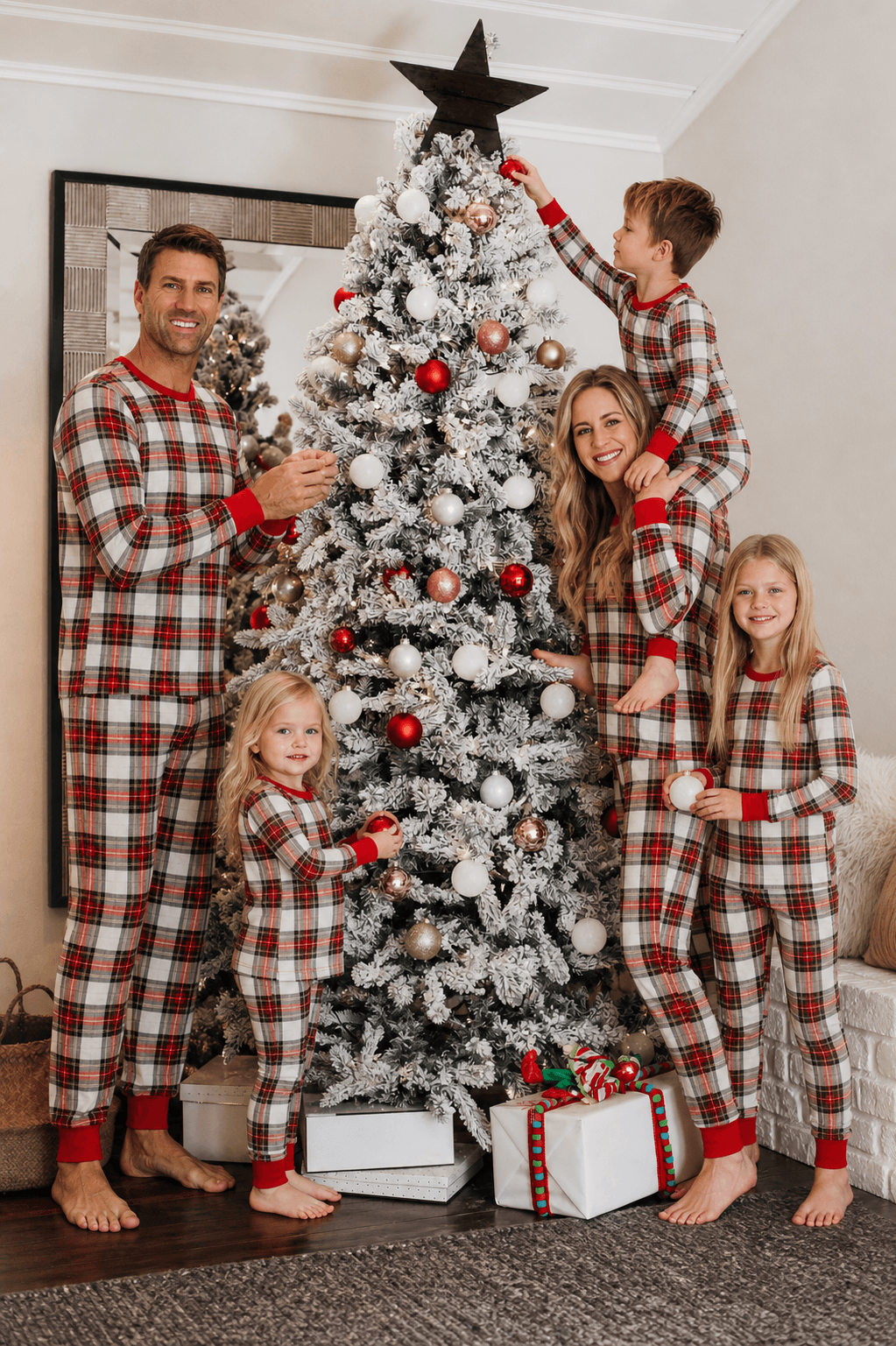 Family wearing matching red and cream tartan Christmas pyjamas with red ribbed cuffs