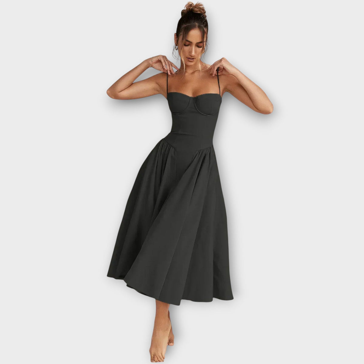 Woman wearing a sleeveless sweetheart corset midi dress with spaghetti straps and a full gathered skirt