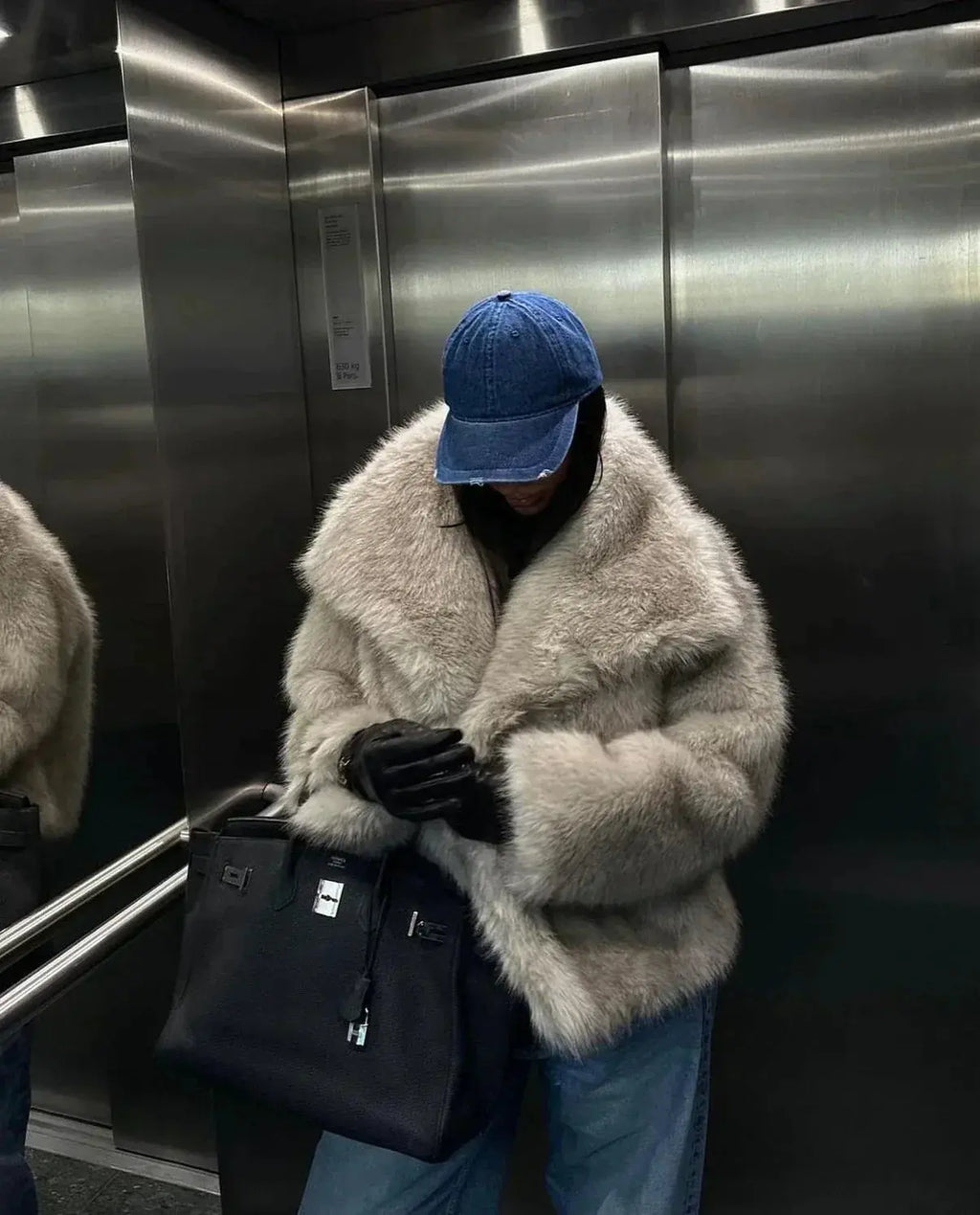 Grey faux fur jacket with oversized collar worn open over jeans