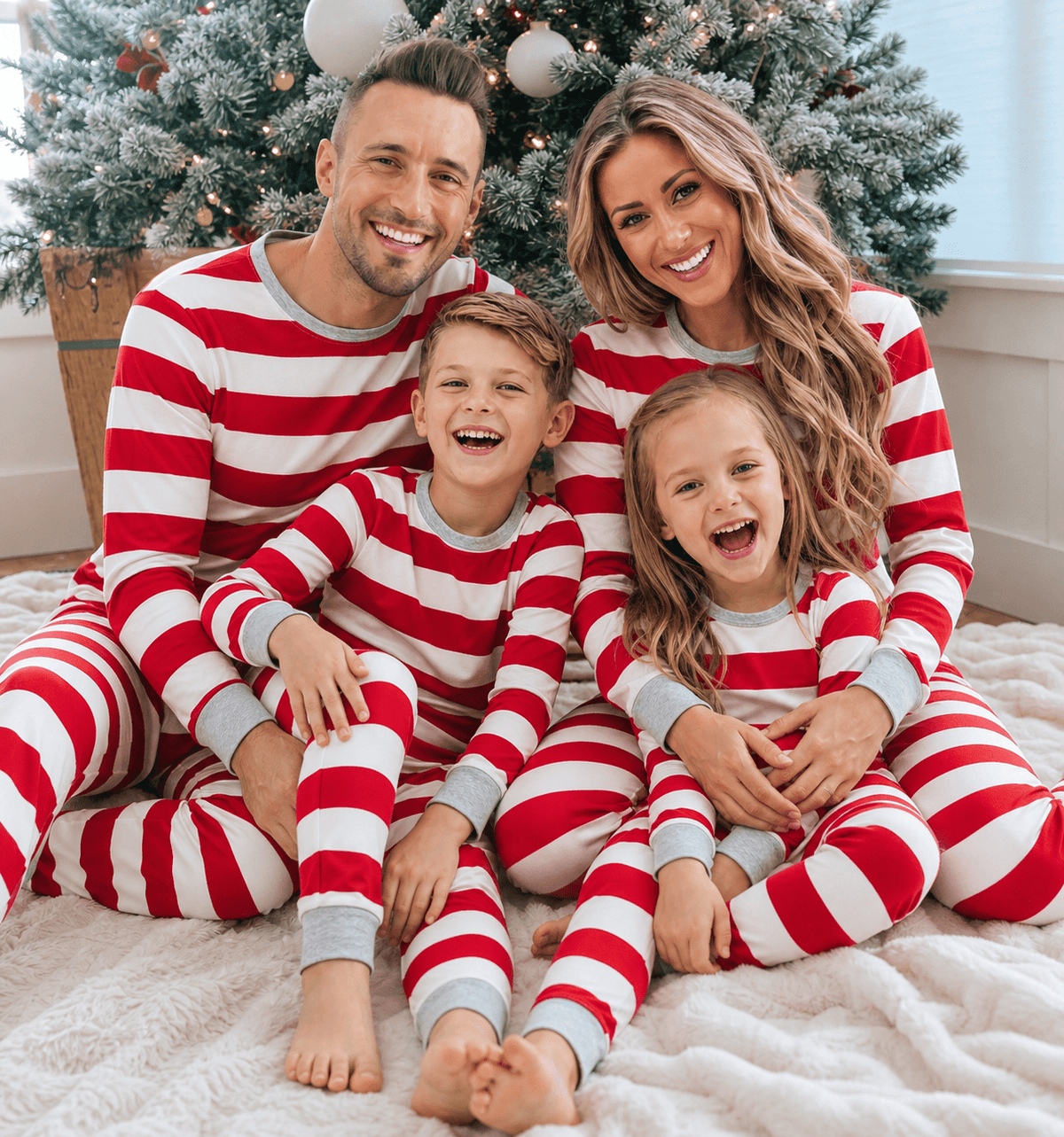 Family wearing matching red and white striped Christmas pyjamas with grey ribbed cuffs - view 2