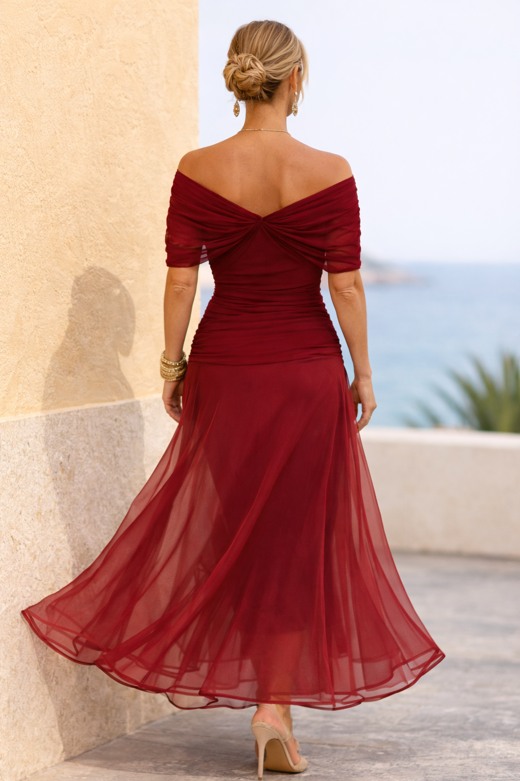 Woman wearing a draped off-shoulder maxi party dress with ruched waist and sheer flowing skirt - view 15