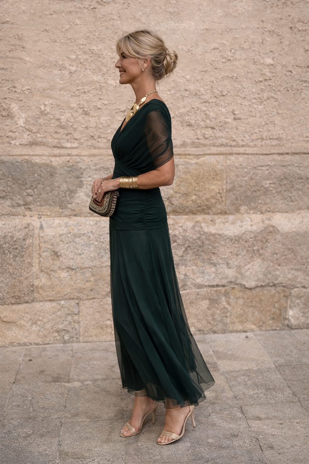 Woman wearing a draped off-shoulder maxi party dress with ruched waist and sheer flowing skirt - view 6